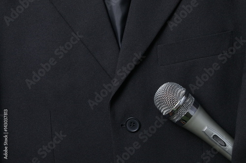 Grey business suit in the scene appear the microphone also. 