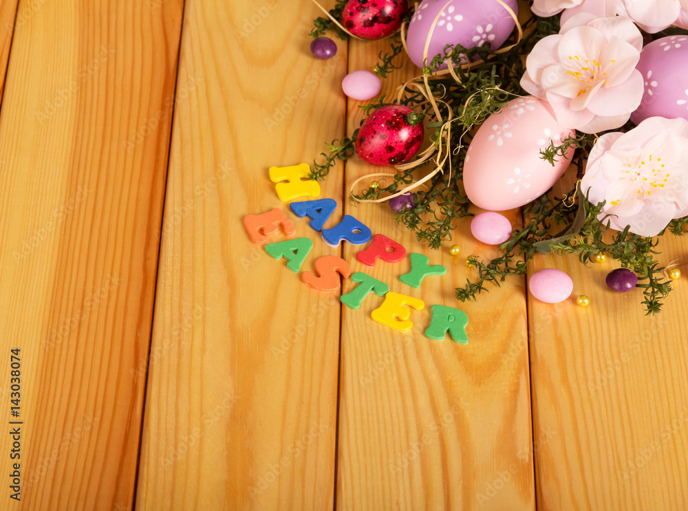 Eggs, candy, flowers, grass, words Happy Easter in light wood.
