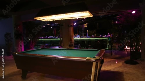 illuminated empty billiard table in the night bar