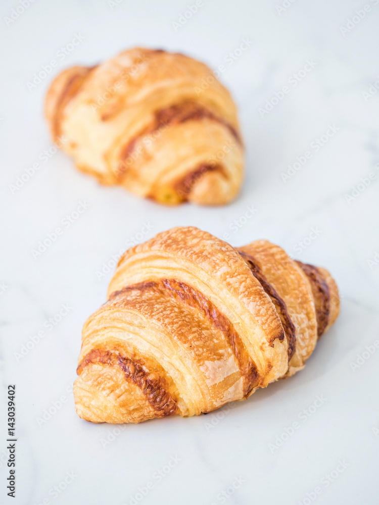 Fresh croissant on white marble table