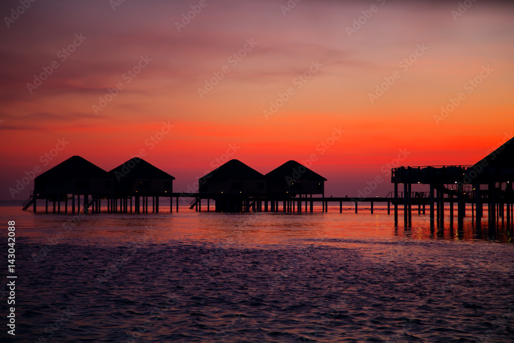 Silhouette of water bungalows at twilight, beautiful landscape