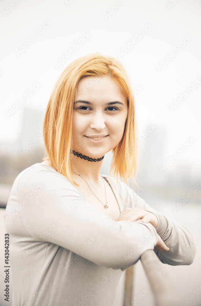 Girl with red hair against the backdrop of the morning city