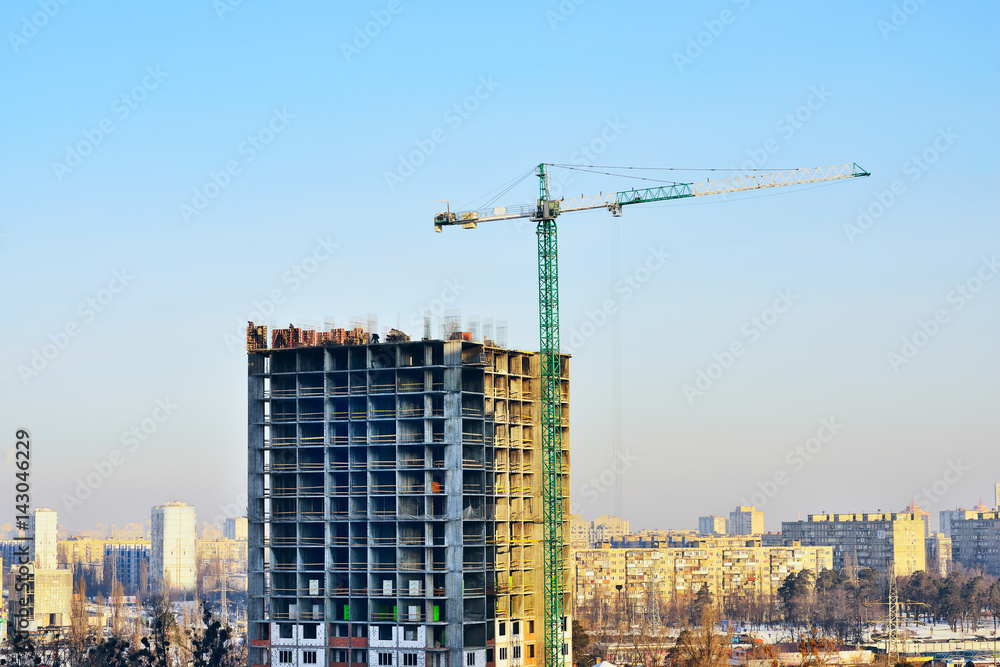 Building site with crane against sky. Construction of new high-rise from concrette and steel.