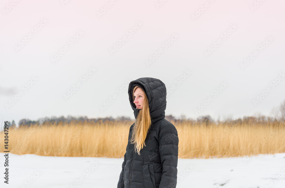 Pensive woman blonde in black apparel on a winter background Pensive woman blonde in black apparel on a winter background