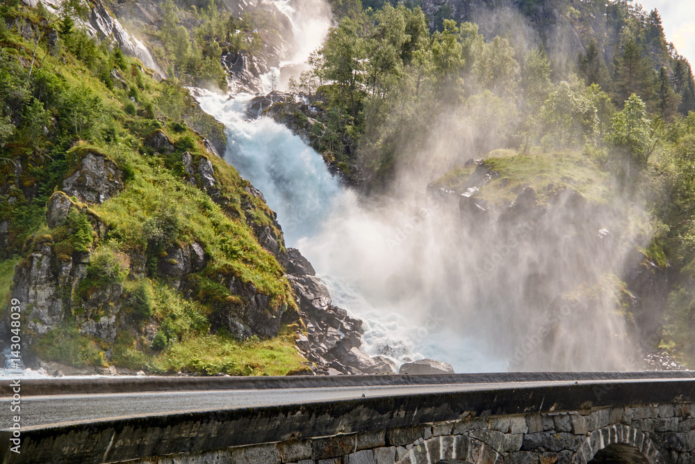 Laatefossen in Norway running under a granite bridge with a road on