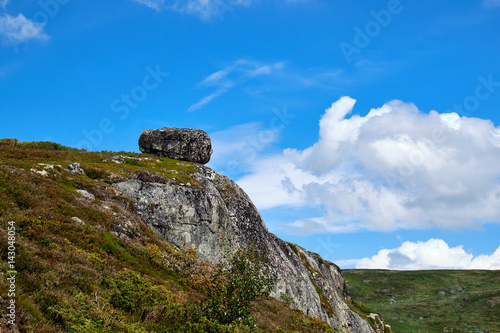 Canvas Print Big granite boulder lying on the outmost edge of a Mountain  crag in a summer la
