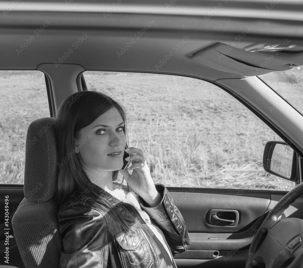black and white attractive girl in the car talking on the phone. black and white attractive girl in the car talking on the phone.