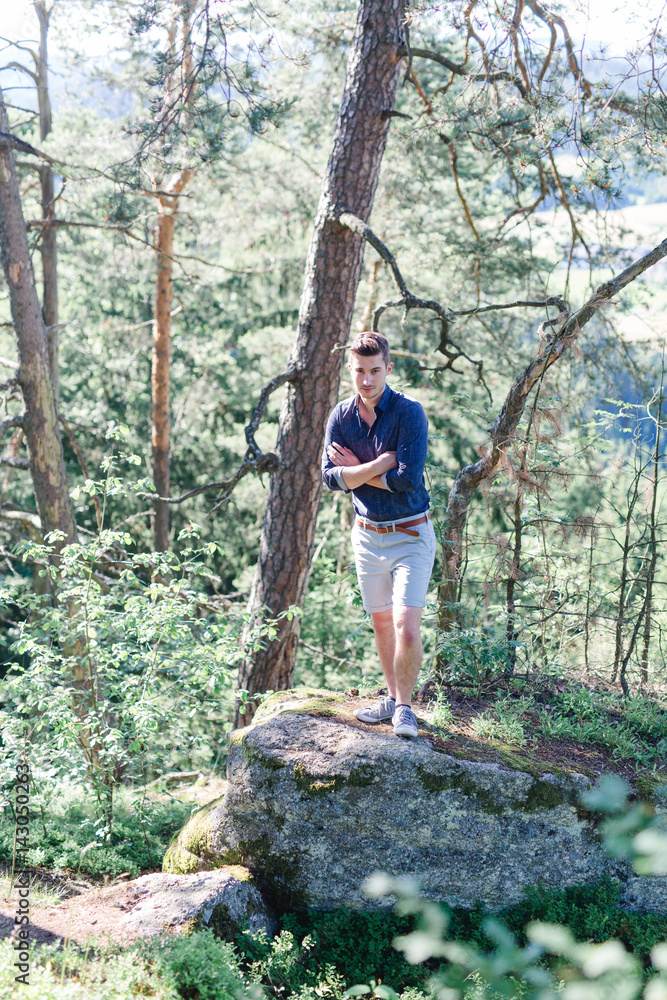 Junger Mann in dem Wald mit kurzer Hose und Hemd Junger Mann in dem Wald mit kurzer Hose und Hemd
