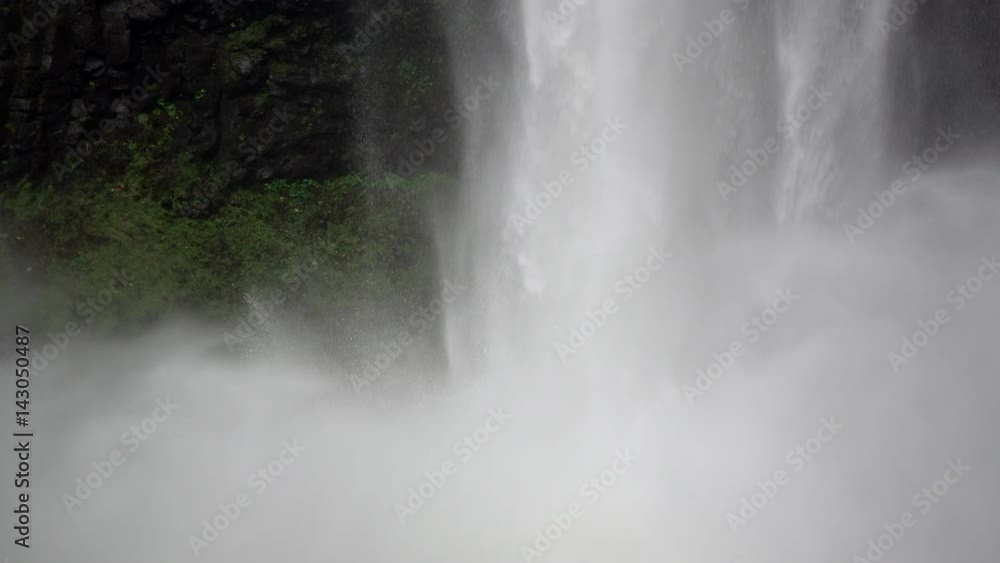 Close up shot of a waterfall crashing down into a body of water Close up shot of a waterfall crashing down into a body of water