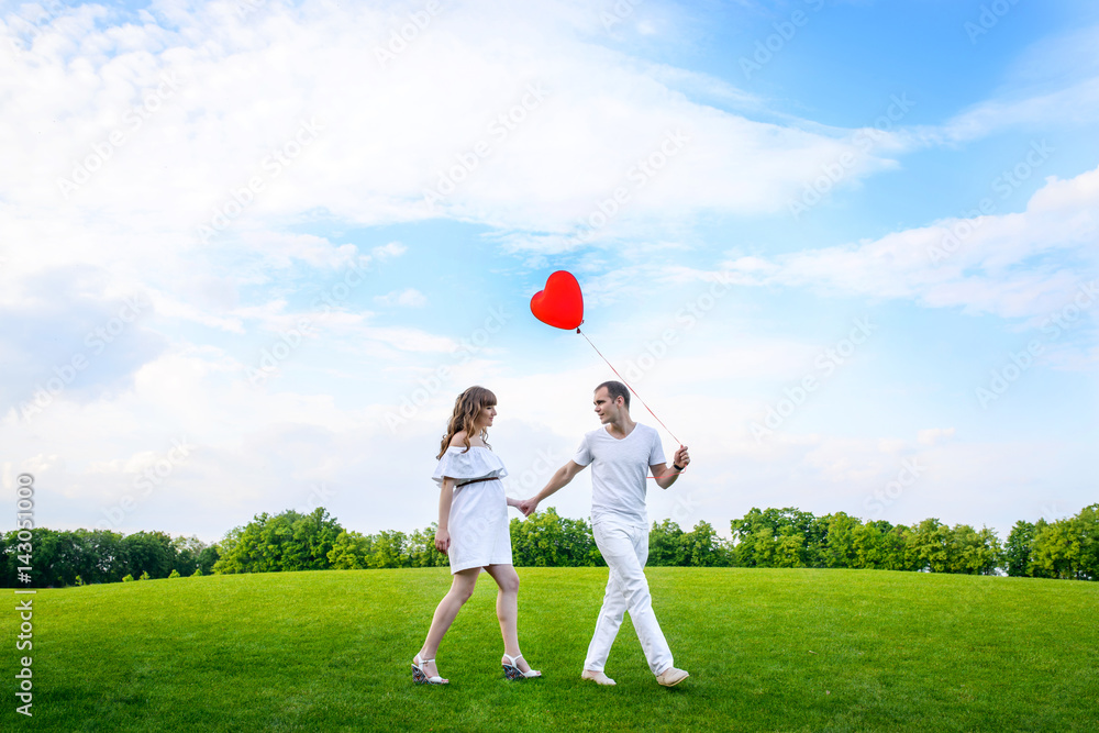 happy young family spending time in the park outdoors,man and woman in the park on a background of blue sky happy young family spending time in the park outdoors,man and woman in the park on a background of blue sky