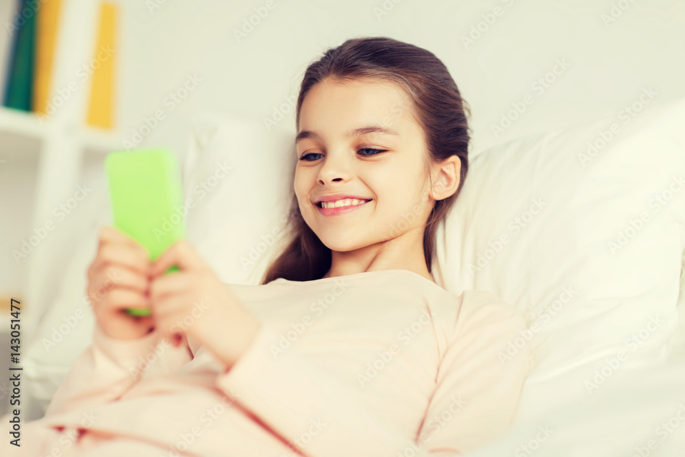 happy girl lying in bed with smartphone at home happy girl lying in bed with smartphone at home