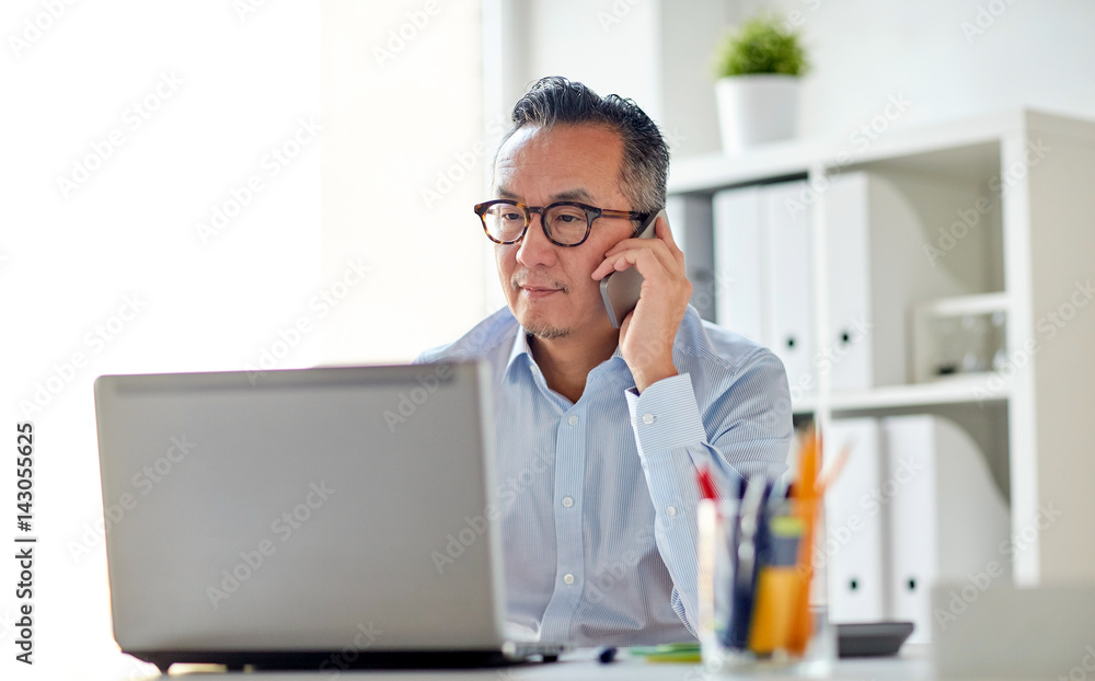 businessman with laptop calling on smartphone