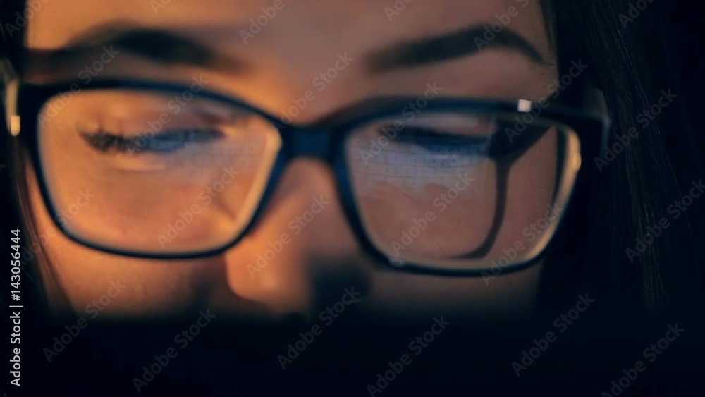 Woman working with tablet touch screen. Reflection of tablet in glasses. Woman working with tablet touch screen. Reflection of tablet in glasses.