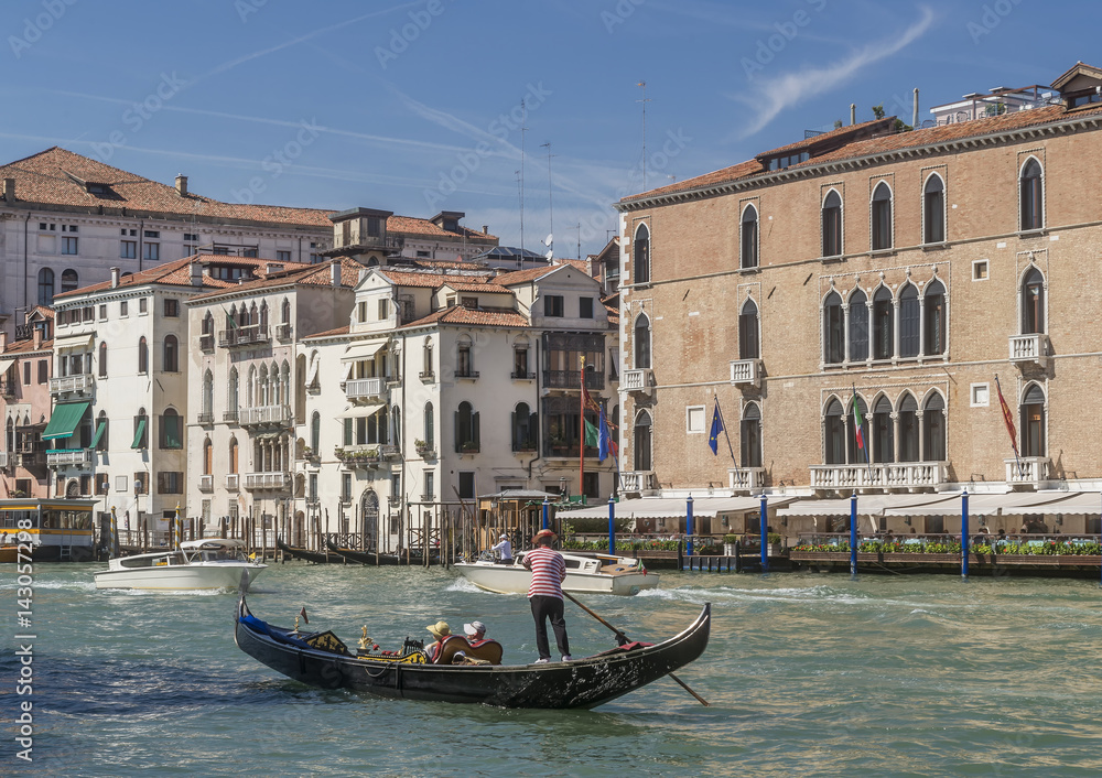 A traditional Venetian gondola sailing on the Grand Canal near the Hotel Gritti Palace, Venice, Italy