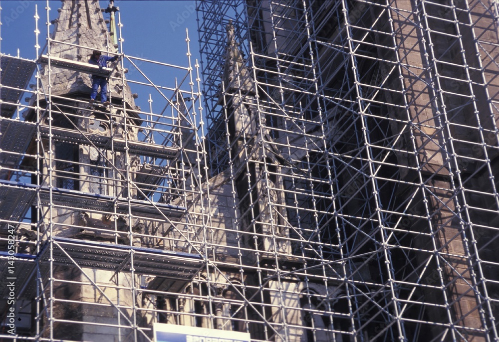 Ouvrier du bâtiment sur échafaudage rénove une église