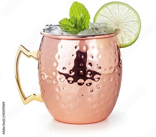 moscow mule cocktail in a copper mug garnished with lime and mint leaves