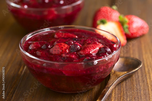 German Rote Gruetze (red groats) red berry pudding made of strawberry, blueberry, raspberry and redcurrants, photographed with natural light (Selective Focus one third into the dessert)