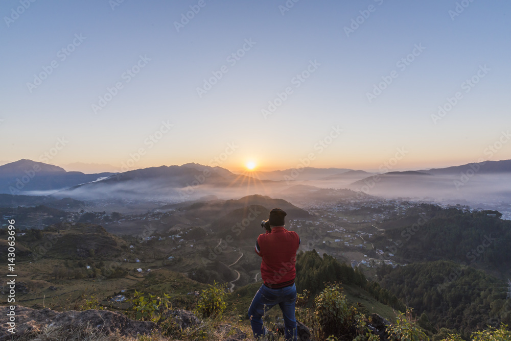 Photographer in action, clicking a beautiful Himalayan Sunrise.