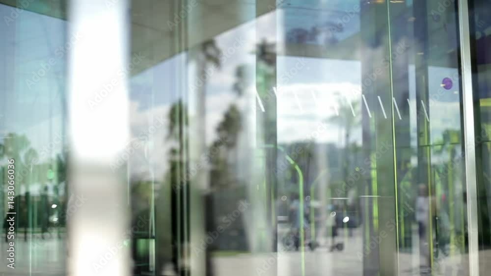 People using automatic revolving glass door or entering rotating