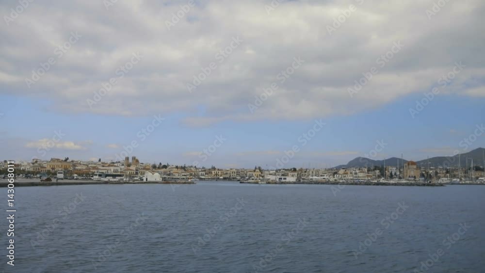 Entering the beautiful marina of Greek island. There are a lot of small houses at the seafront. Entering the beautiful marina of Greek island. There are a lot of small houses at the seafront.