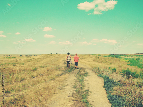 two male tourists are on the road in a Sunny summer day. toned photo.