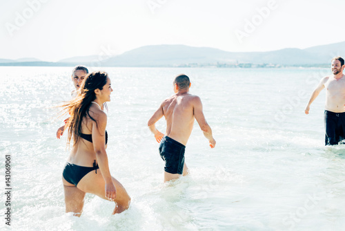 Group of friends millennials wearing swimsuits splashing around - happiness, interaction, togetherness concept