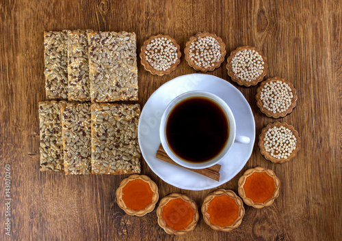 A cup of coffee and biscuits on a wooden table. View from above. © sosiukin