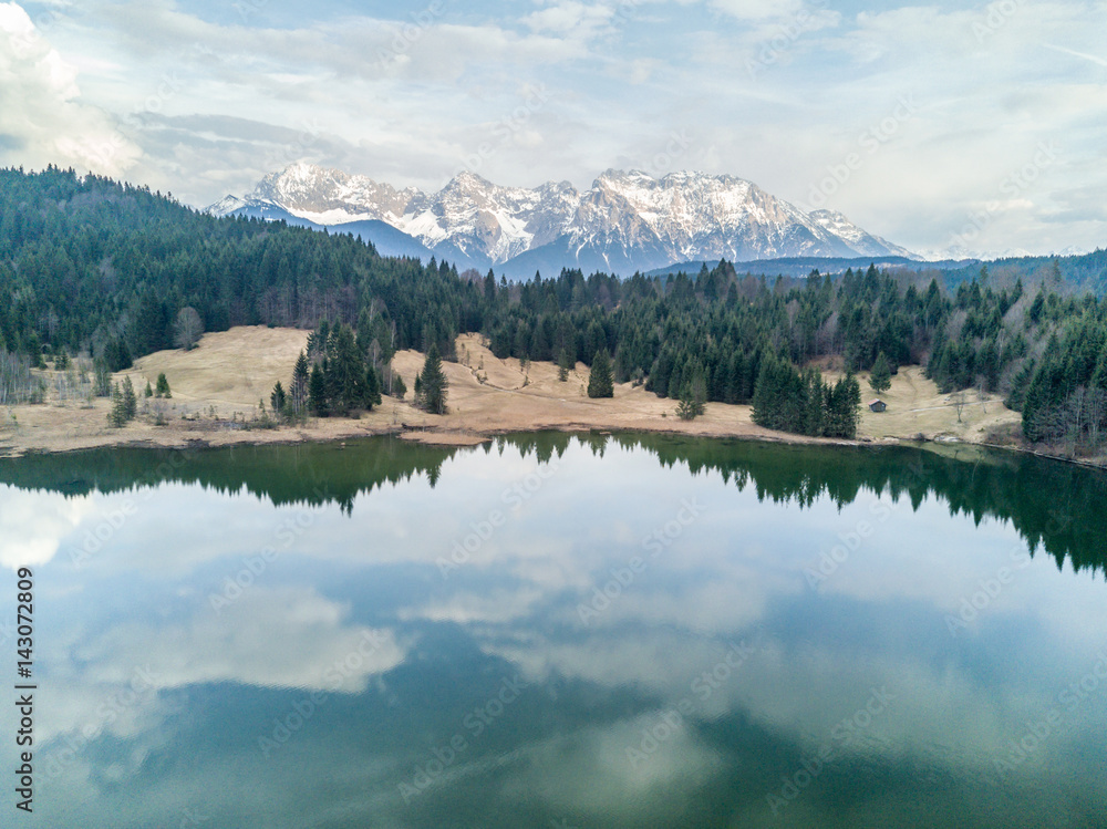 Aerial view from a drone of the geroldsee panorama with the lake in front and mountains in the background.