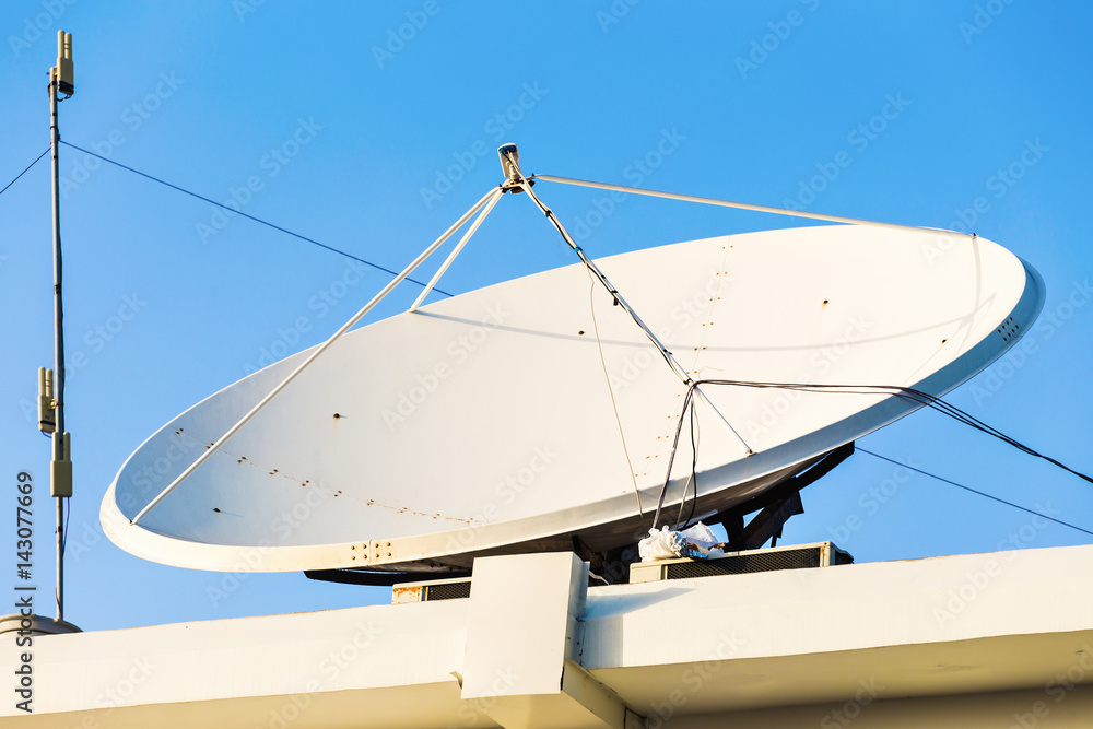 satellite dish and TV antennas on the house roof with blue sky background satellite dish and TV antennas on the house roof with blue sky background