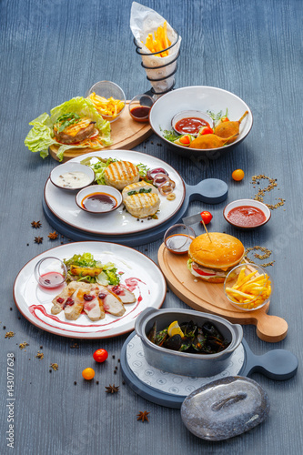 Dining still life. Dishes from chicken and turkey  mussels in saucepan and naked burger