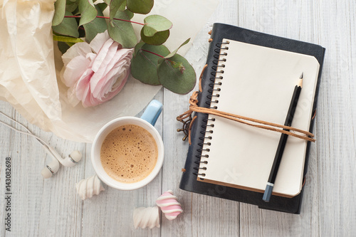 Open blank notebook, bouquet, cup of coffee, earphones