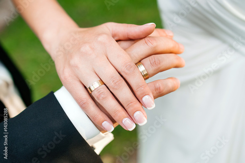 Hands of newlyweds with wedding rings.