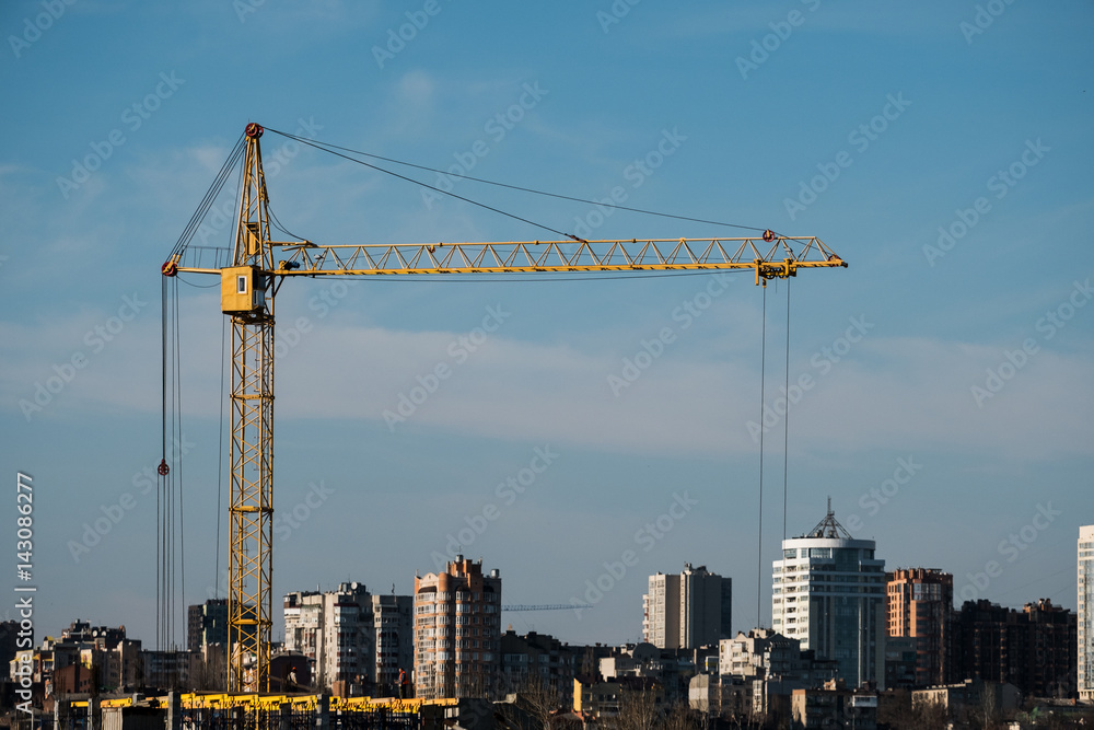 construction crane and Assembly of the structure of the building object on the background of the city