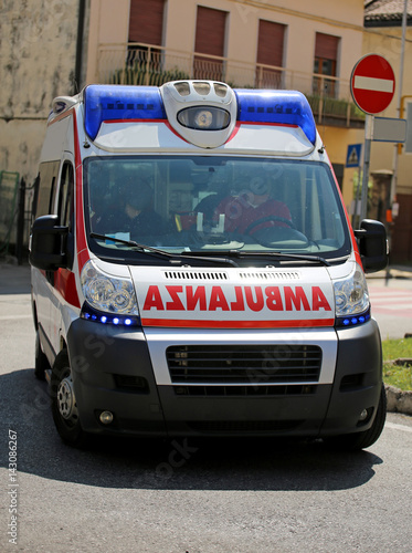 Ambulance on the city road during an emergency with blue sirens
