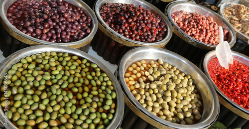 Italian market stall with olives and red peppers for sale