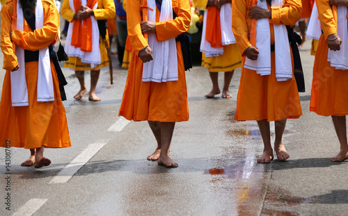 soldiers with orange clothes march through the city during a fes