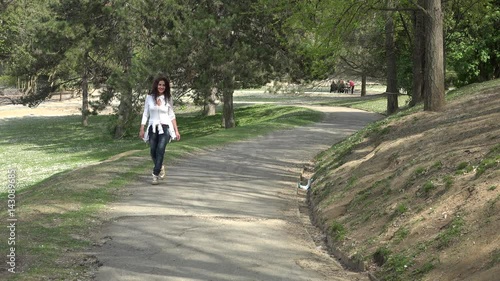 Wallpaper Mural woman arriving in park walking in an uphill road in a park while the poplar fluff falls as snow Torontodigital.ca