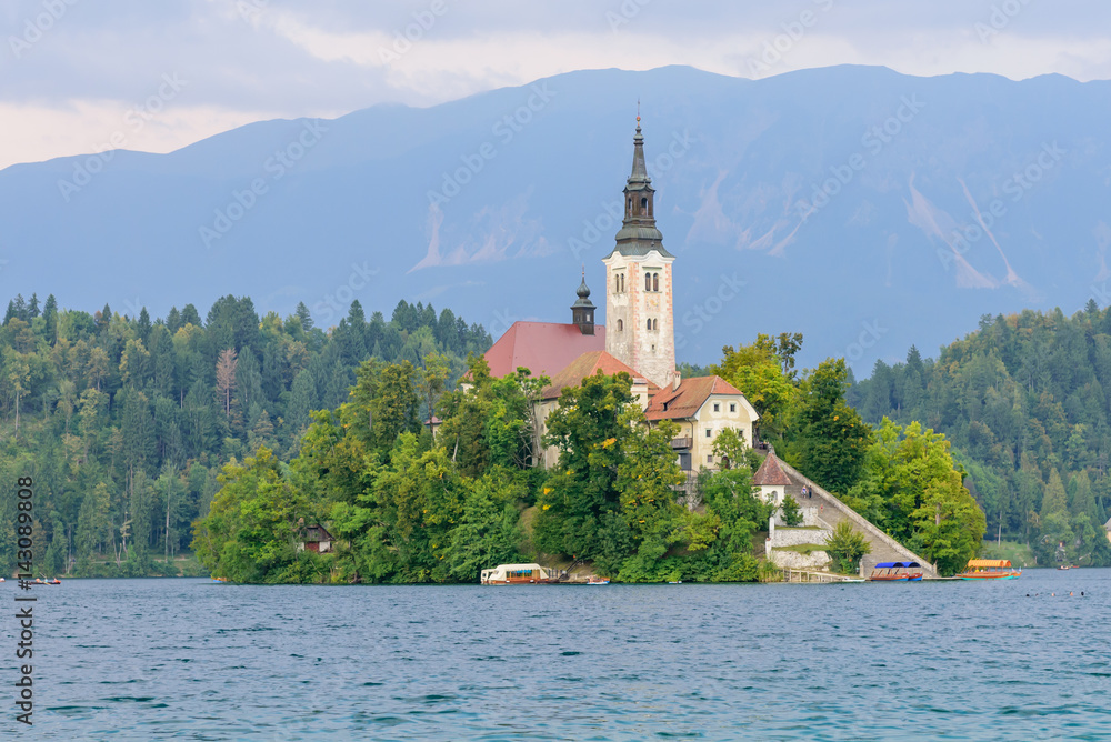 Lake Bled with St. Marys Church of Assumption on small island. Bled, Slovenia, Europe. Mountains and valley on background. 