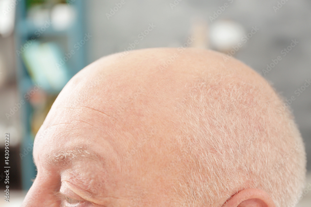 Naklejka premium Senior bald man on blurred background, closeup
