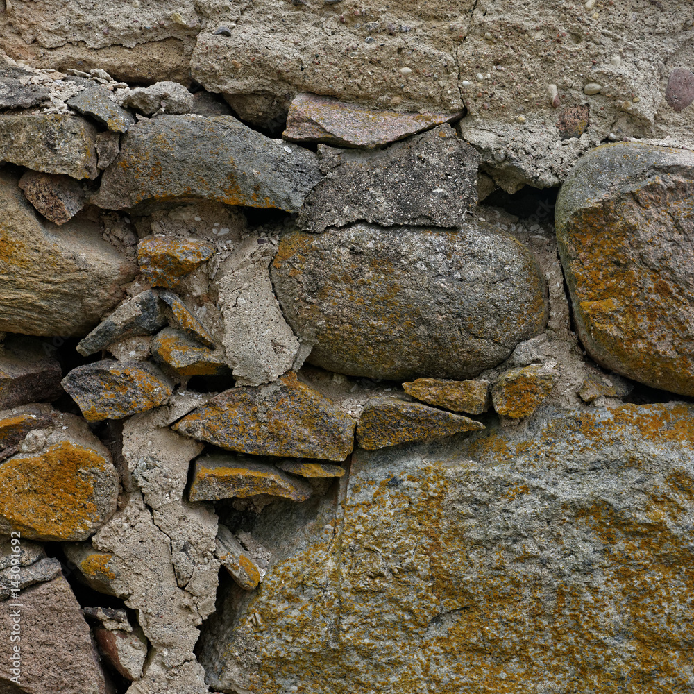 Close up of part of old log house stone foundation with cracks and lichens Xanthoria parietina