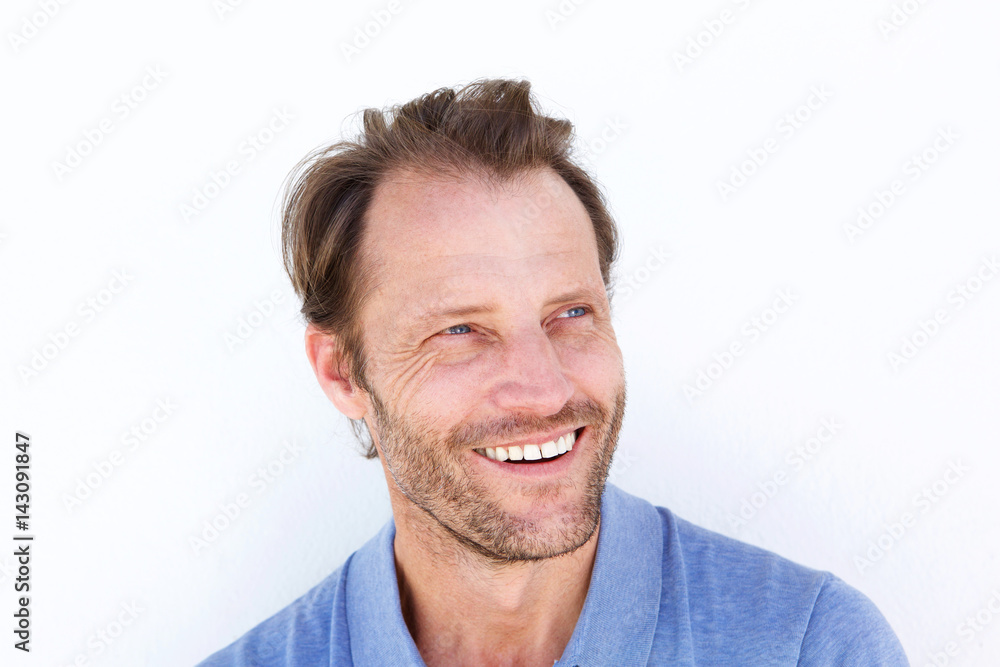 Close up smiling older man against white wall Close up smiling older man against white wall