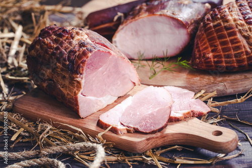 Fotografija Smoked piece of ham sliced meat on wooden desk