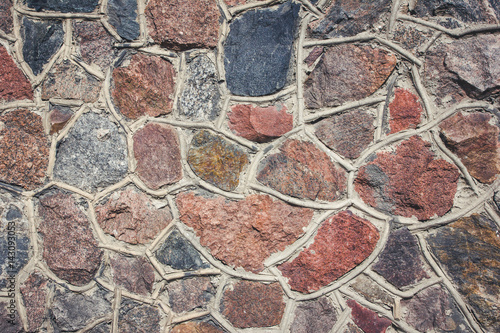 Mosaic rough wall made with rocky stones background.