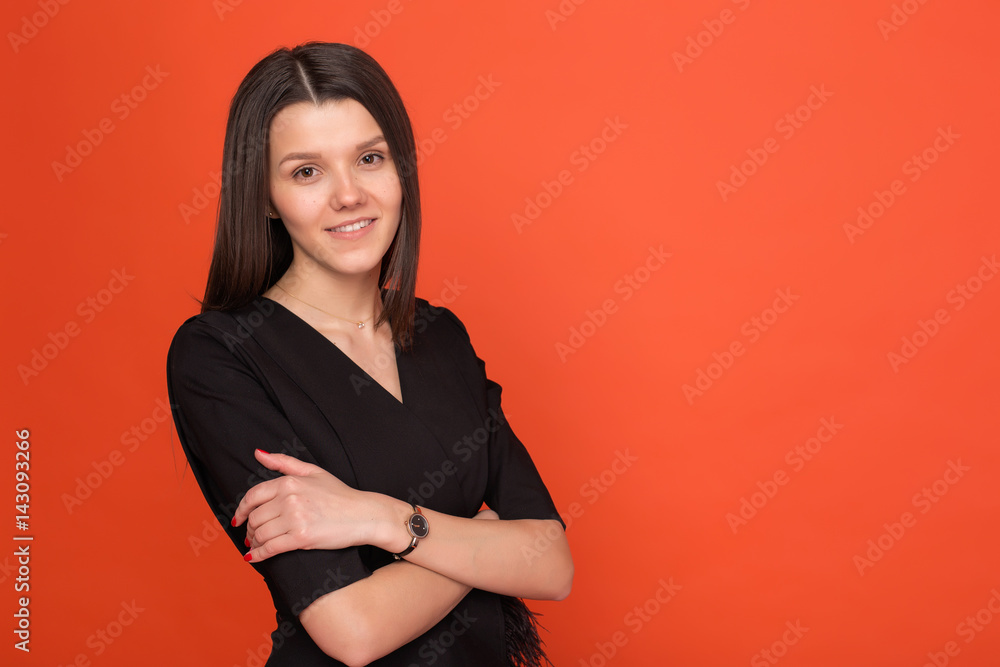 Obraz premium Beautiful young girl in a business suit on a red background