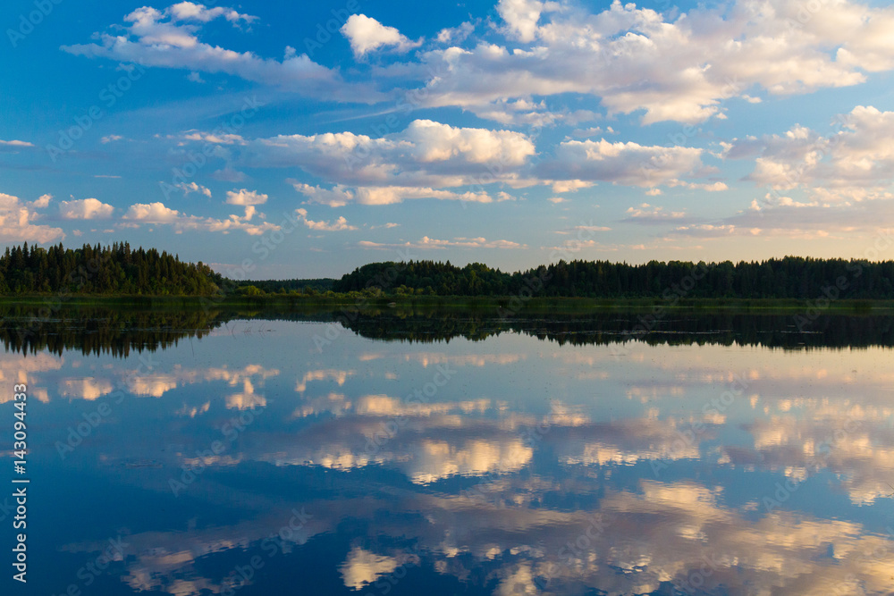 Obraz premium Cloudy sky reflected in the smooth surface of the river