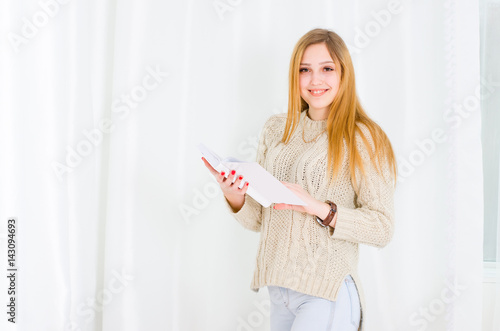 Beautiful young woman holding a book in hands