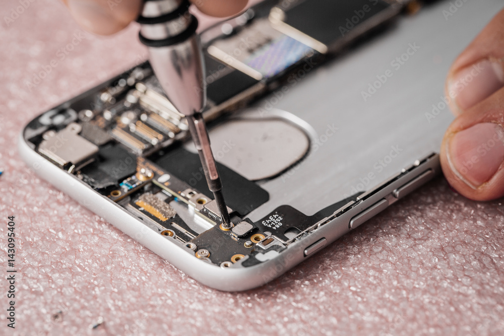 Close up hands of a service worker repairing modern smarphone. Close up hands of a service worker repairing modern smarphone.