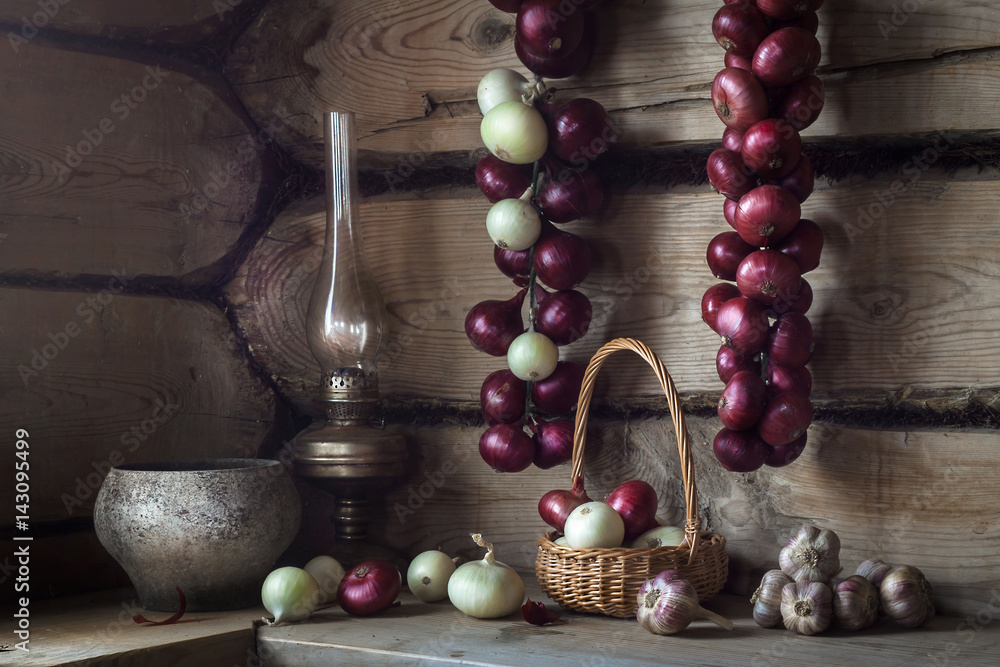 Still-life with rural utensils and onions in old house Still-life with rural utensils and onions in old house