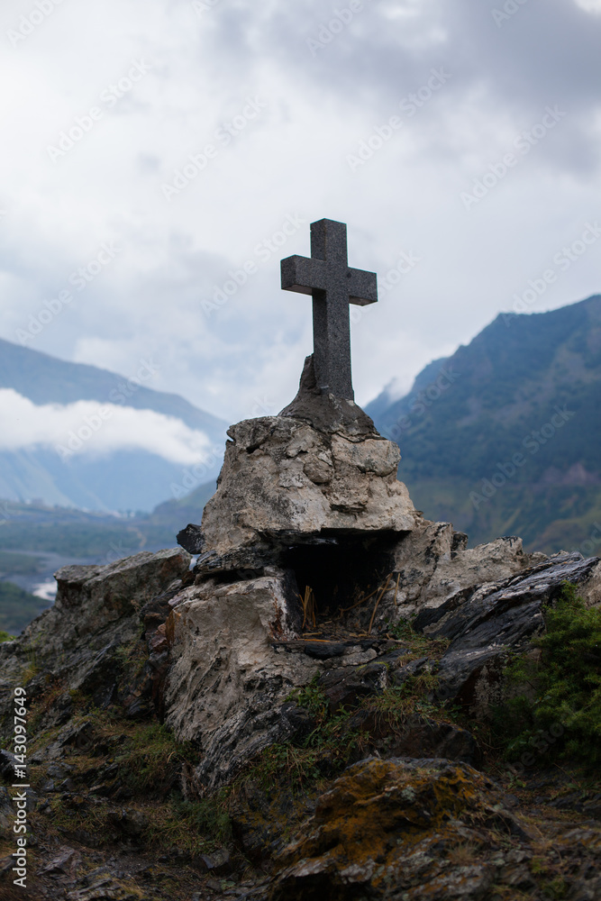 GEORGIA, KAZBEGI Orthodox cross near Caucasus mountains.