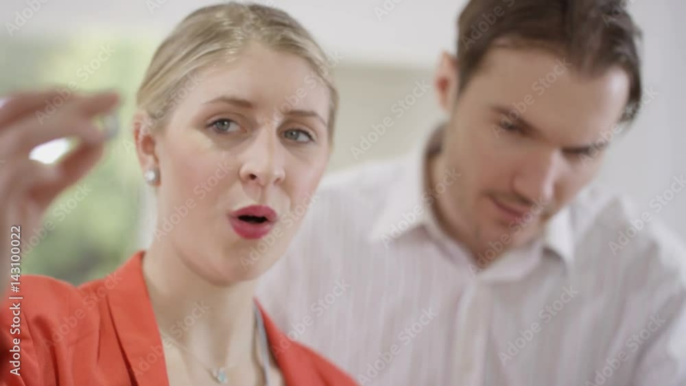  Engineers working together, looking at computer screen & examining component.
